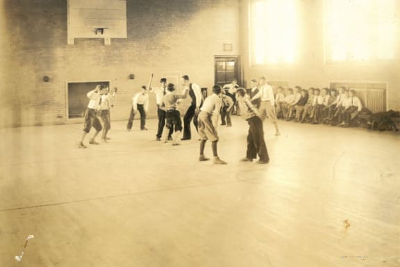 a group of men playing a game of baseball in a gym