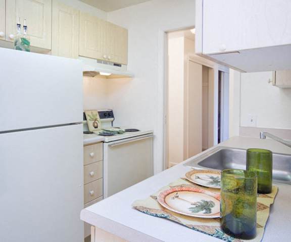 A kitchen with white appliances and counters at Bristol Square Apartments.