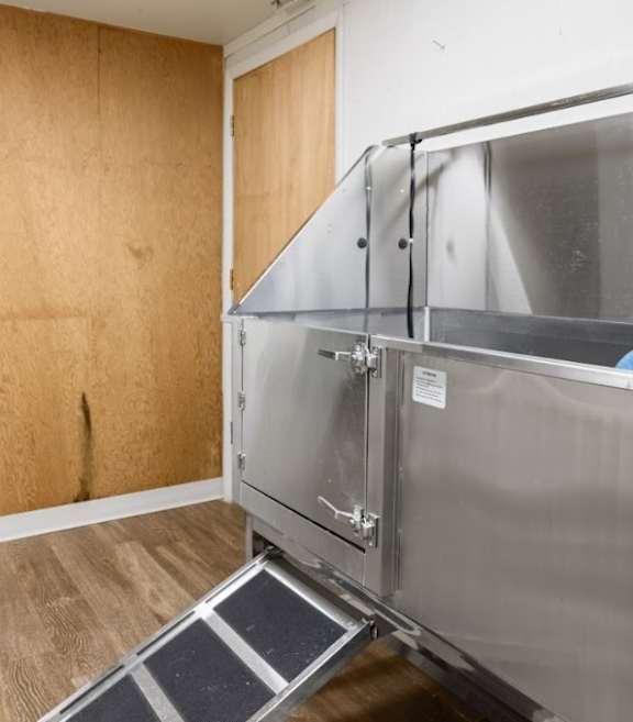 A kitchen with a black refrigerator, stainless steel oven, and wooden cabinets.