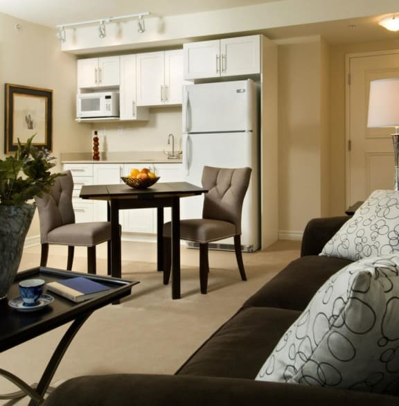A living room with a couch and a table with a bowl of fruit on it