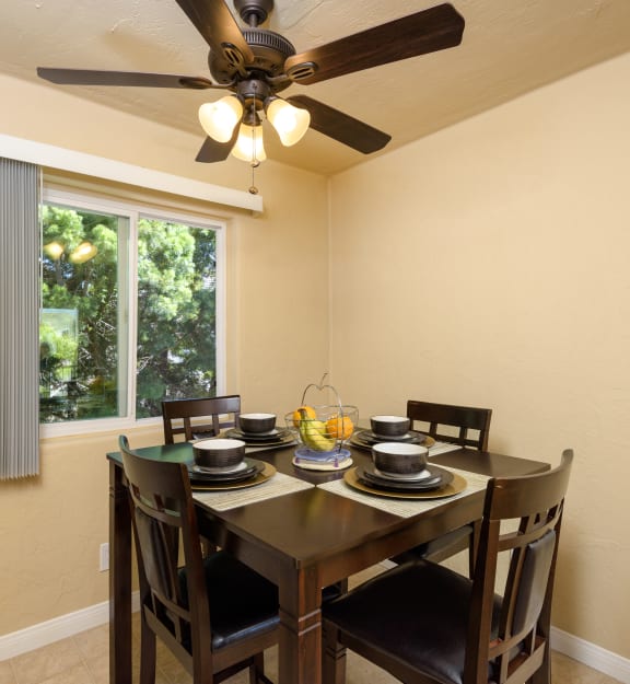 a dining room with a table and chairs and a ceiling fan