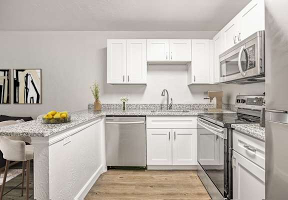 a kitchen with white cabinets and stainless steel appliances
