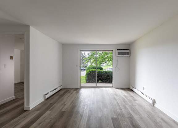 A room with a sliding glass door leading to a garden.