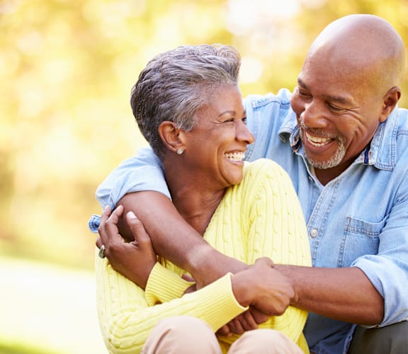 a man and woman laugh together in a park