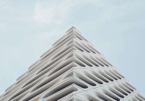 A tall building with a pyramid shape and a lot of windows.