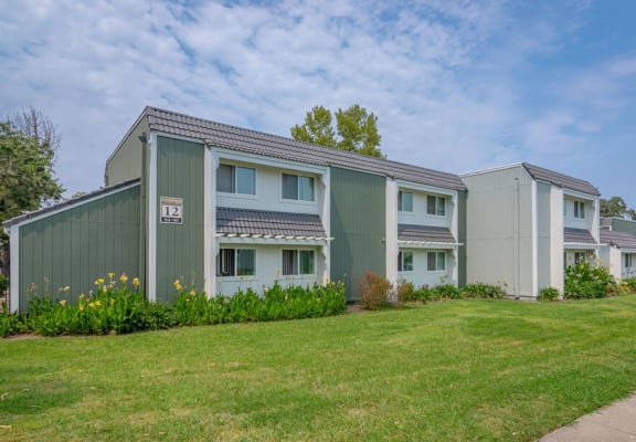 a row of green and white houses next to a sidewalk at Napa Green Apartments LLC, Napa, CA 94559