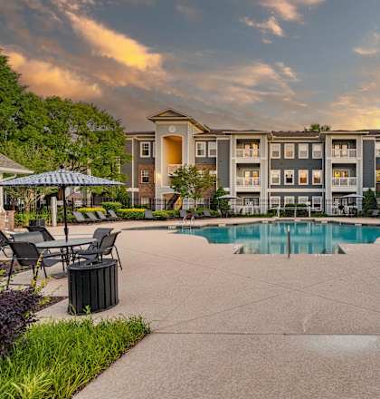 A large building with a pool in front of it.