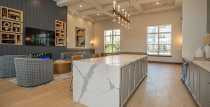 A modern living room with a fireplace and a large marble island at The Ashton at East Park Apartments, Kennesaw, GA, 30144