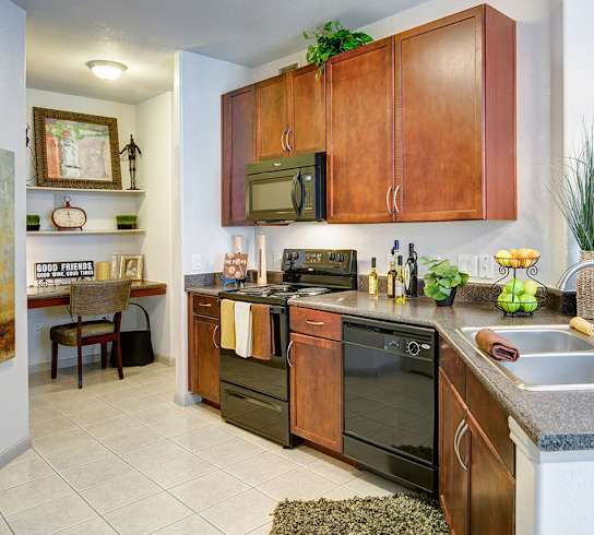 A kitchen with wooden cabinets and a black oven.