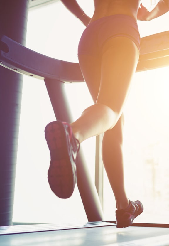 A woman is running on a treadmill.