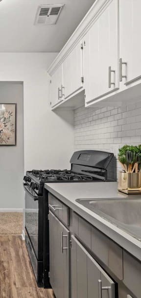 a kitchen with white cabinets and a stainless steel sink