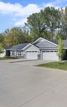 A row of houses with grey roofs and white garage doors.