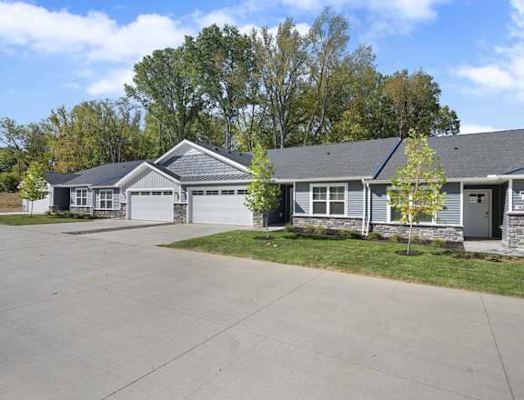 A row of houses with grey roofs and white garage doors.