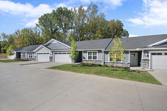 A row of houses with grey roofs and white garage doors.