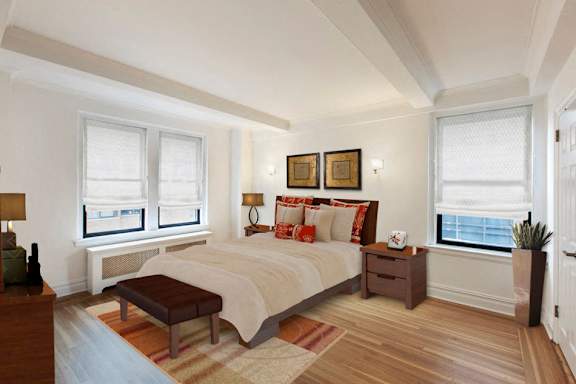 A bedroom with a large bed and a window with a view of the city.at Sutton Collection, New York New York