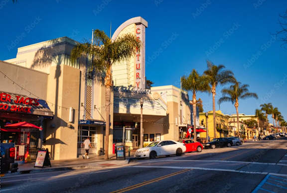 a shopping center on a city street with palm trees