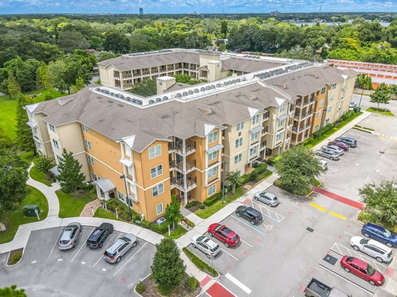 an aerial view of an apartment building and parking lot