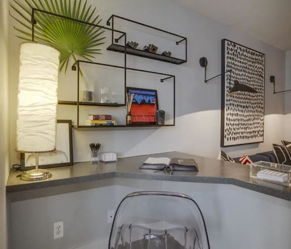 A modern kitchen with a grey countertop and a white lamp.