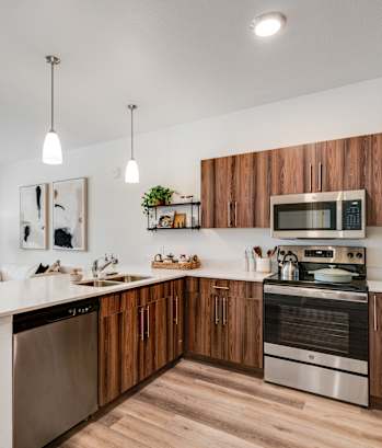 A modern kitchen with wooden cabinets and stainless steel appliances.