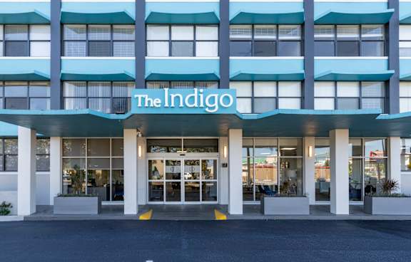 The front of a building with the name "The Indigo" on it.