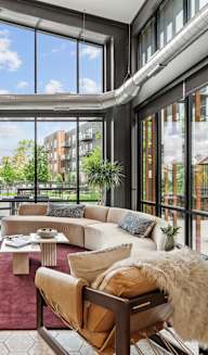 A large, modern living room with a view of the outdoors.