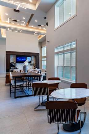 A table tennis table is in the middle of a room with a pool table and a table fan at The Waverly at Winter Haven Apartments, Winter Haven, 33884