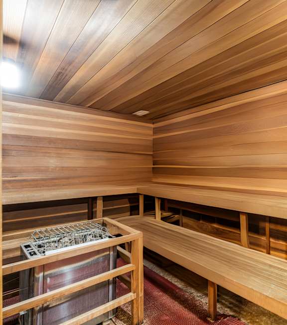 a large sauna with wooden walls and a wooden bench