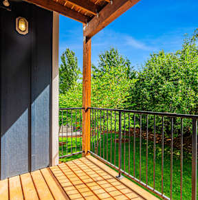 A balcony with a black door and a metal railing.