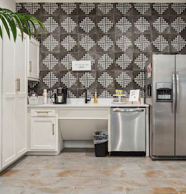 a white kitchen with a stainless steel refrigerator and sink