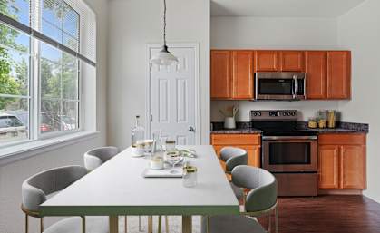 A modern kitchen with a dining table set for six.