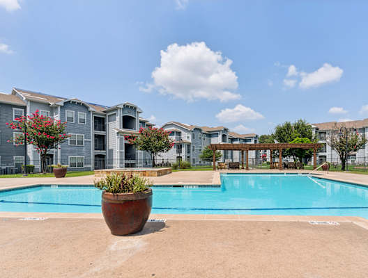 a large swimming pool with apartments in the background