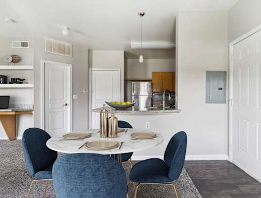 a dining room with a table and chairs and a kitchen