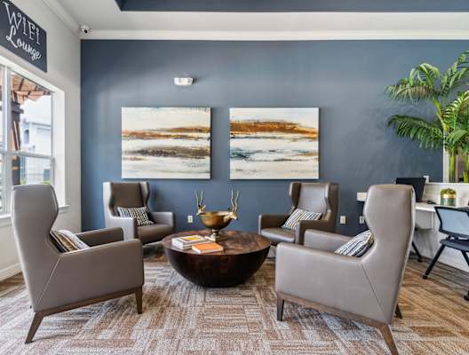 a living room with blue walls and chairs and a table