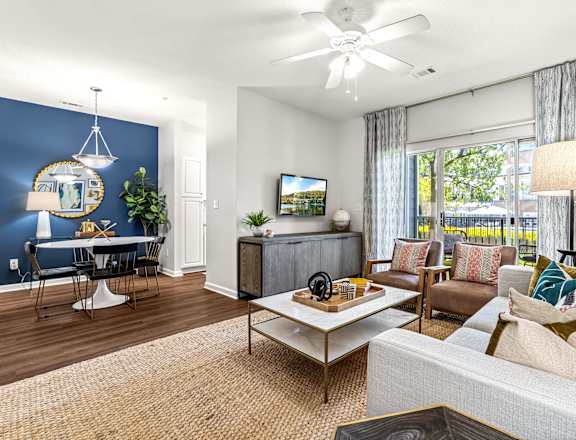 A living room with a white couch, a coffee table, and a television.