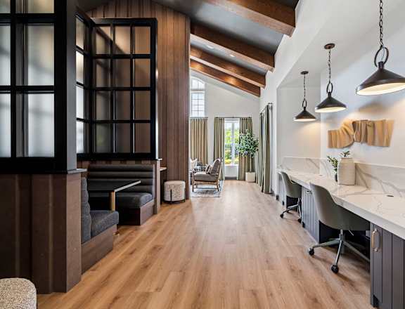 A modern office space with wood floors and a long table.