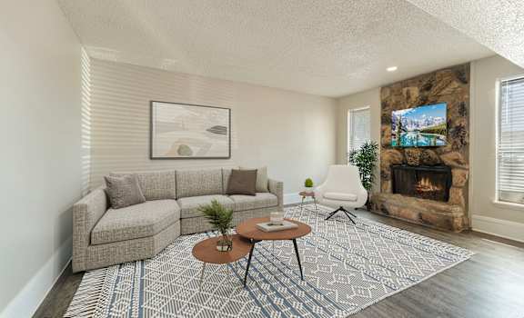 A living room with a grey couch, a coffee table, and a fireplace.