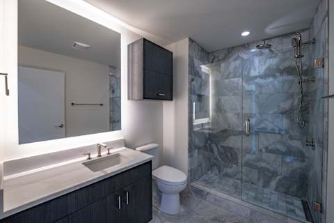 A bathroom with a sink, toilet, and shower.