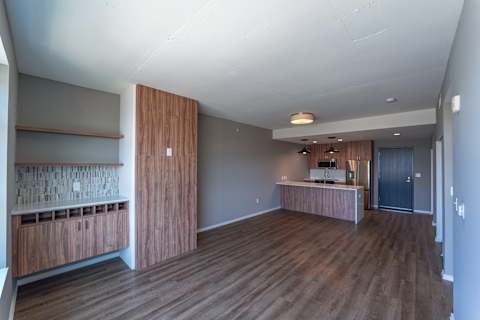 A room with wooden floors and a counter with a sink.