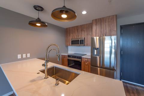 A modern kitchen with a sink and stainless steel appliances.