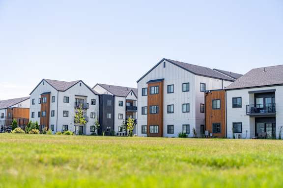 A row of modern townhouses with balconies and multiple windows.