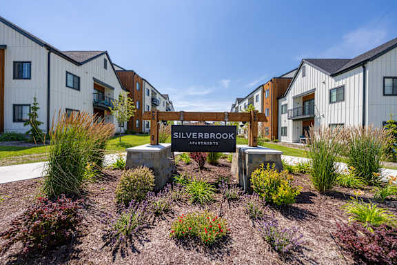 A sign that says Silverbrook Apartments is in front of a building.