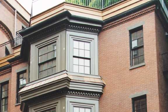A tall building with a balcony on the top floor.