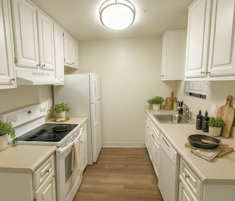 A kitchen with white cabinets and a wooden floor.at Vintage Pointe, Rohnert Park, CA