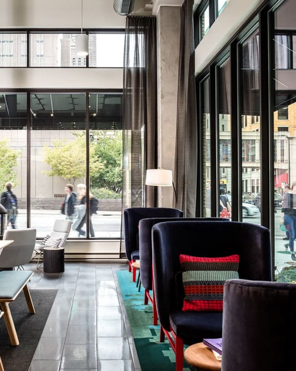 The lobby of Edition Apartments with tables and chairs. 