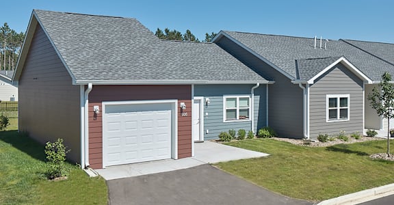 A house with a grey roof and a red garage door.