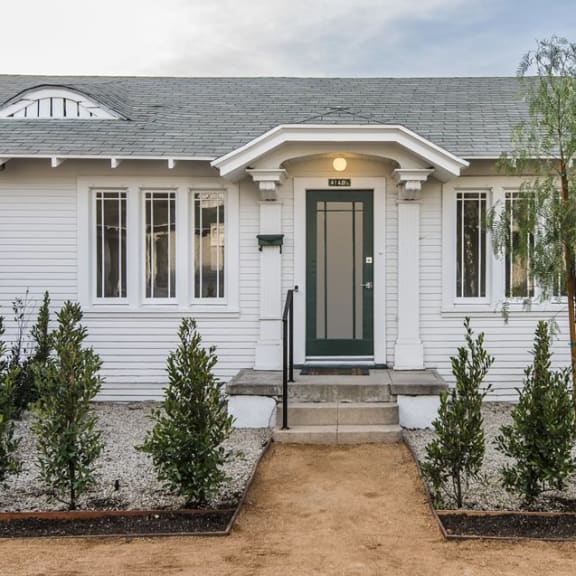 a home with white siding and a green door
