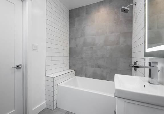a bathroom with a sink a bathtub and a mirror