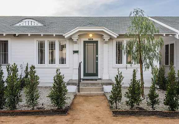 a home with white siding and a green door