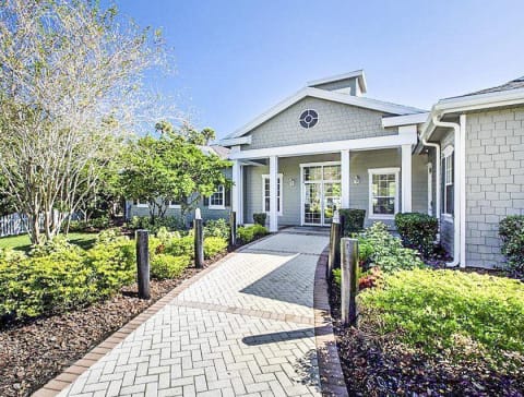 Clubhouse Entrance surrounded by shrubbery and trees