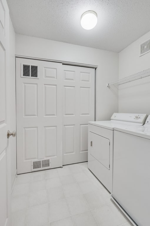 laundry room with washer/dryer and white doors and white floors